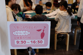 お気に入りはどれ？立体変わり絵9:30-16:30などと書かれた看板の向こうにたくさんの子どもたち。