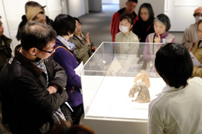 展示ケースを囲む人々。